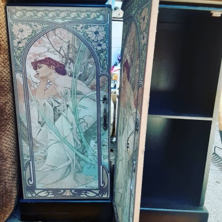 A cabinet door with a painted dark haired woman.