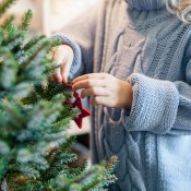 A small Christmas tree being decorated.