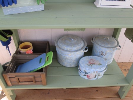Painted storage pots on a potting bench.