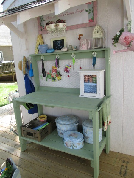 Painted storage pots on a potting bench.