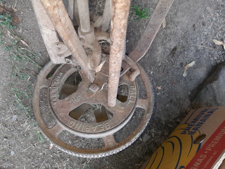 The blade and wheel of an old metal push mower.