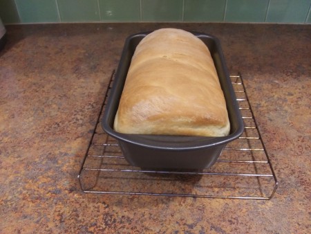 A baked loaf of bread in a pan.