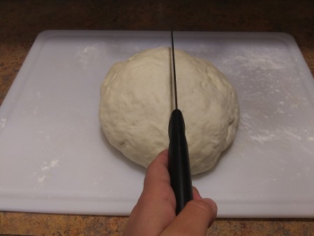 Cutting the ball of dough in half.