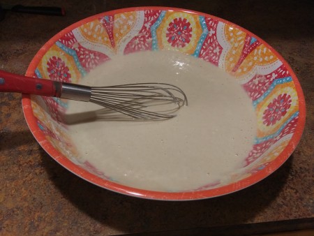 Whisking the wet and dry ingredients together.