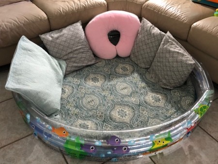 The baby pool with pillows around.