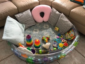 The baby pool with pillows and toys for playtime.