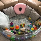 The baby pool with pillows and toys for playtime.