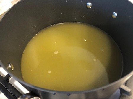 A soup pot with chicken broth.