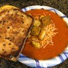 A bowl of tomato soup with a grilled cheese sandwich.