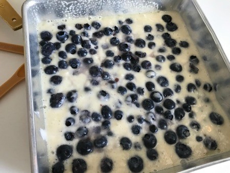 Adding blueberries to the cobbler batter.