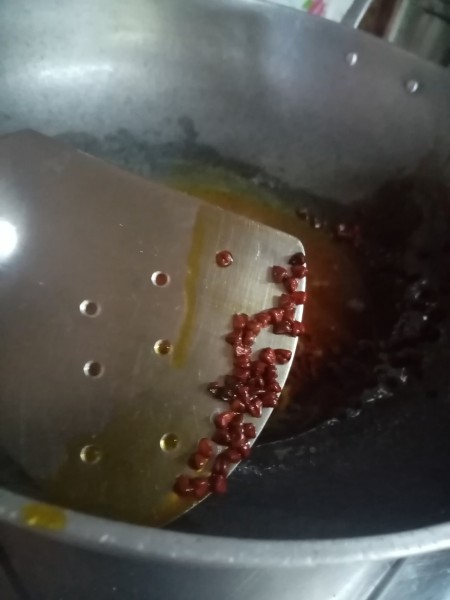 Removing annatto seeds from the oil.