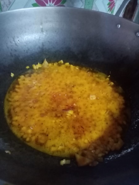 Adding minced garlic and onion to the flavored oil.