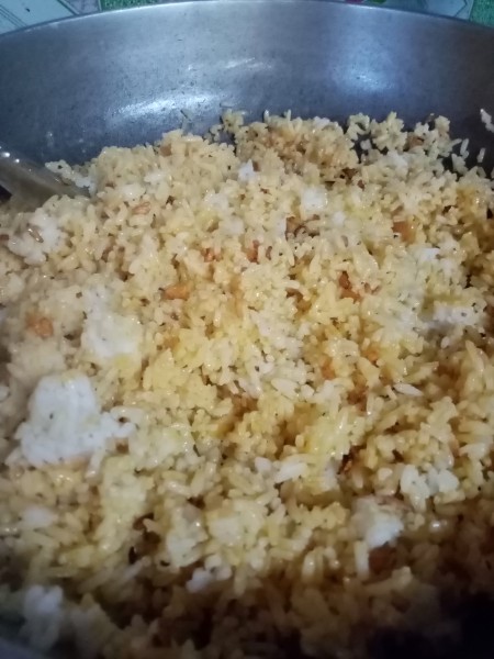 Adding cooked rice to the oil mixture.