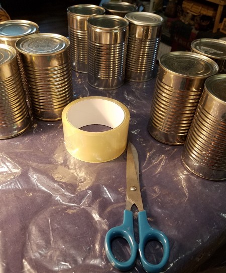 Recycled cans with tape and scissors.