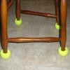 Chair legs with yellow tennis balls on the bottom.