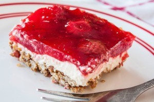 A square of pretzel salad with a strawberry jello topping.