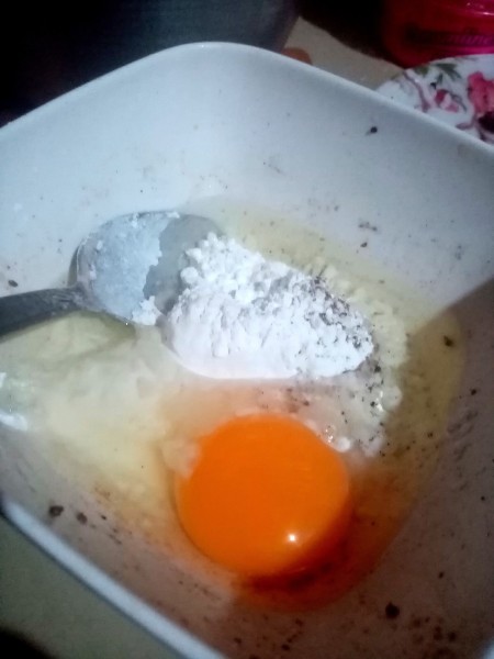 Adding an egg to the flour mixture.