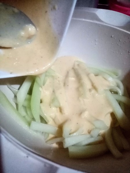 Pouring the batter over the chayote pieces.