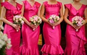 A row of bridesmaids in pink dresses.