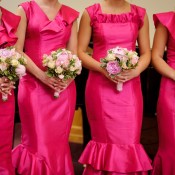 A row of bridesmaids in pink dresses.