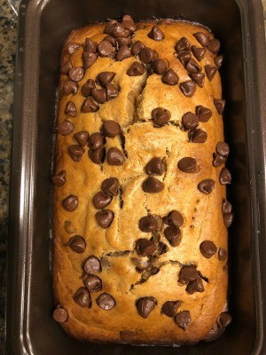 A baked loaf of almond butter chocolate chip bread in the pan.