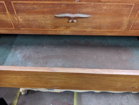 An open drawer at the bottom of a cedar chest.