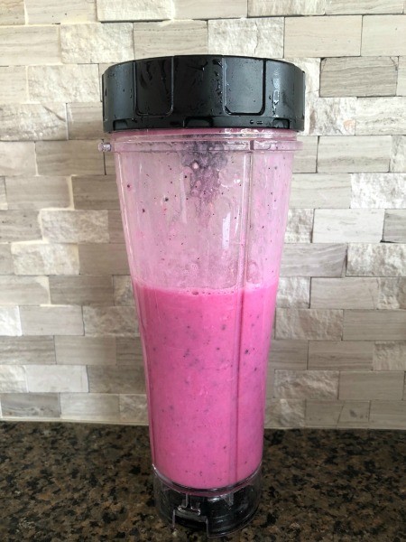 A summer fruit smoothie in a blender cup.