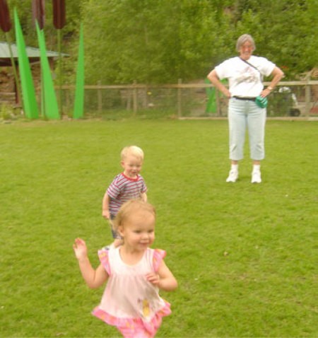 Kids playing in a green space at the zoo.