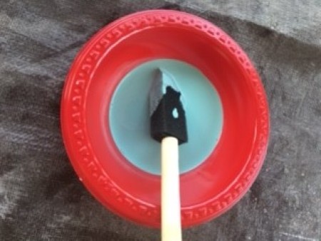 Distressed Finish Stool - blue paint mixed with water in a plastic bowl with a sponge brush