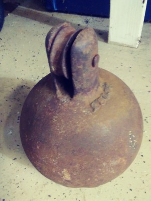 Identifying Old Equipment? - rusty flat bottomed iron ball with a pulley style wheel mounted on top