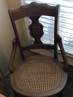 An antique chair with a cane seat.