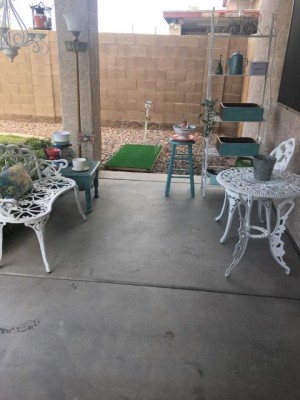 A patio with many containers of plants.