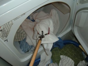 Grabbing laundry from the dryer with a reach extender.