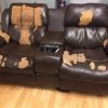 A leather couch with many worn spots.