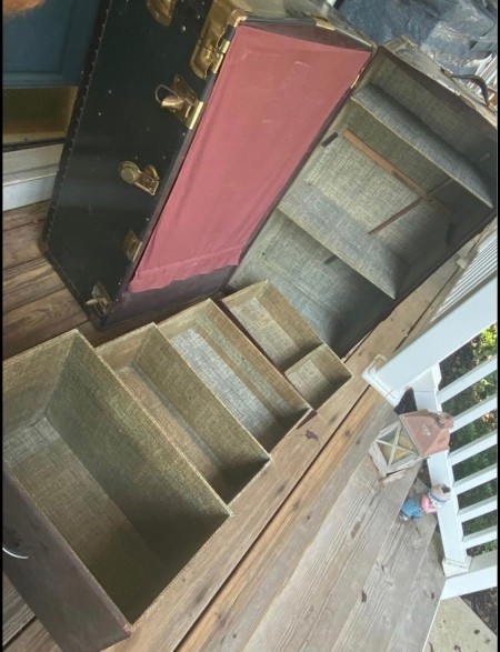 An open steamer chest with the drawers out.