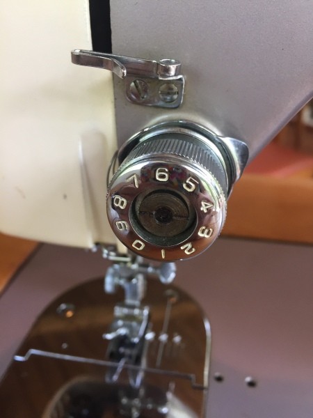 The tension knob on a sewing machine.