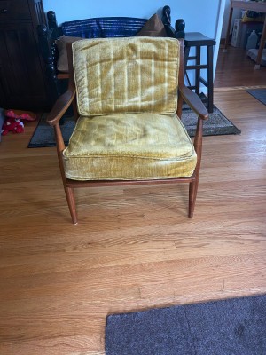 A wooden chair with a yellow cushion.