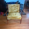 A wooden chair with a yellow cushion.