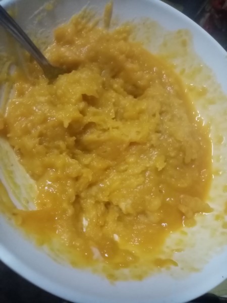 Mashing the sweet potatoes and squash together.