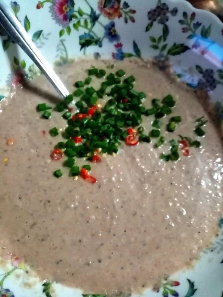 Adding diced vegetables to the mixture.