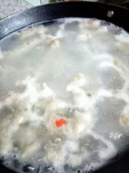 Cooking the small fish cakes in boiling water.