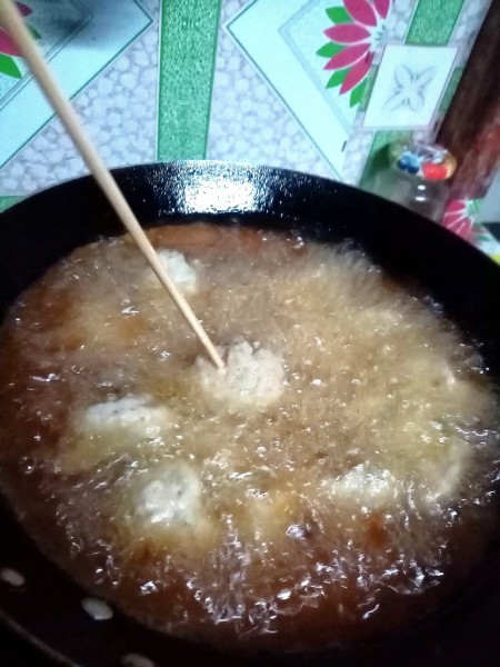 Frying the fish cakes in hot oil.
