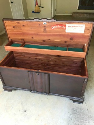 A wooden cedar chest with the lid open.