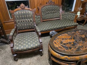 An antique chair with matching loveseat and a coffee table.