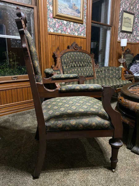 The side of a wooden fabric covered chair.