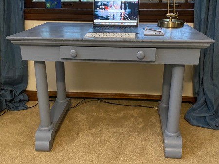 A grey desk with a drawer in the front.