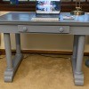 A grey desk with a drawer in the front.