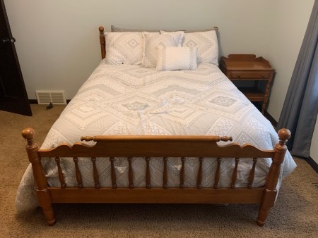 A wooden bed with a headboard and footboard.