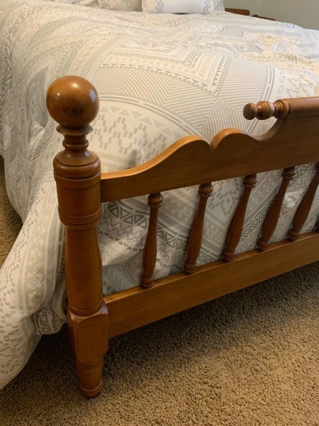 The footboard of a wooden bed.