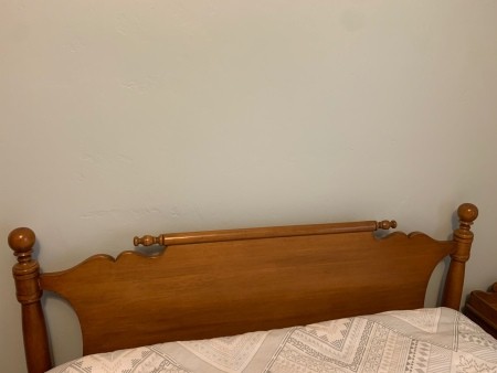 The headboard of a wooden bed.